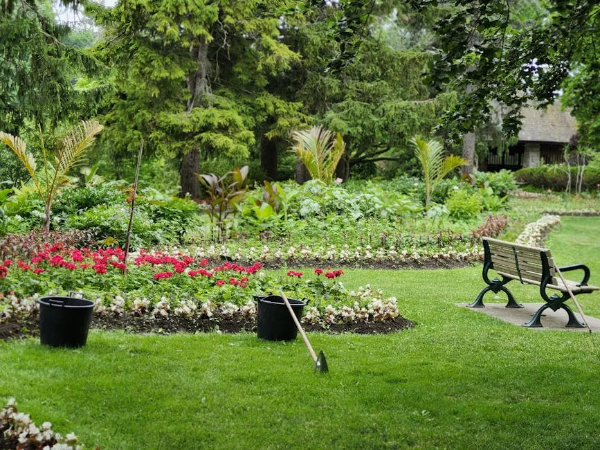 Massif fleuri rouge et banc dans un jardin entretenu